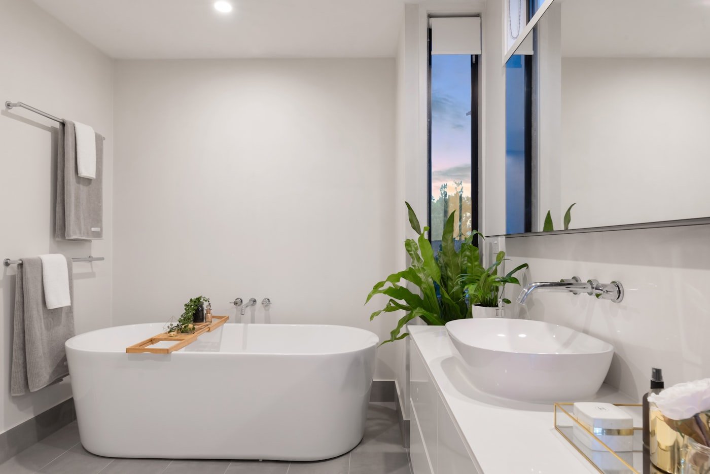 Small bathroom with a tall narrow storage tower beside the toilet