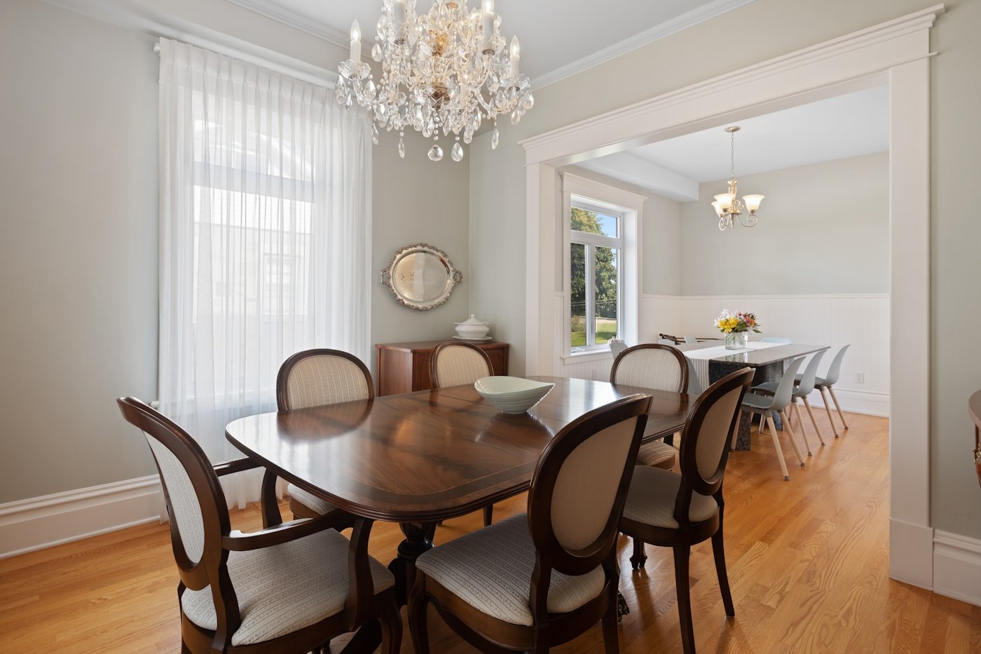 Dining table on a large flat-weave rug that extends well beyond the chairs