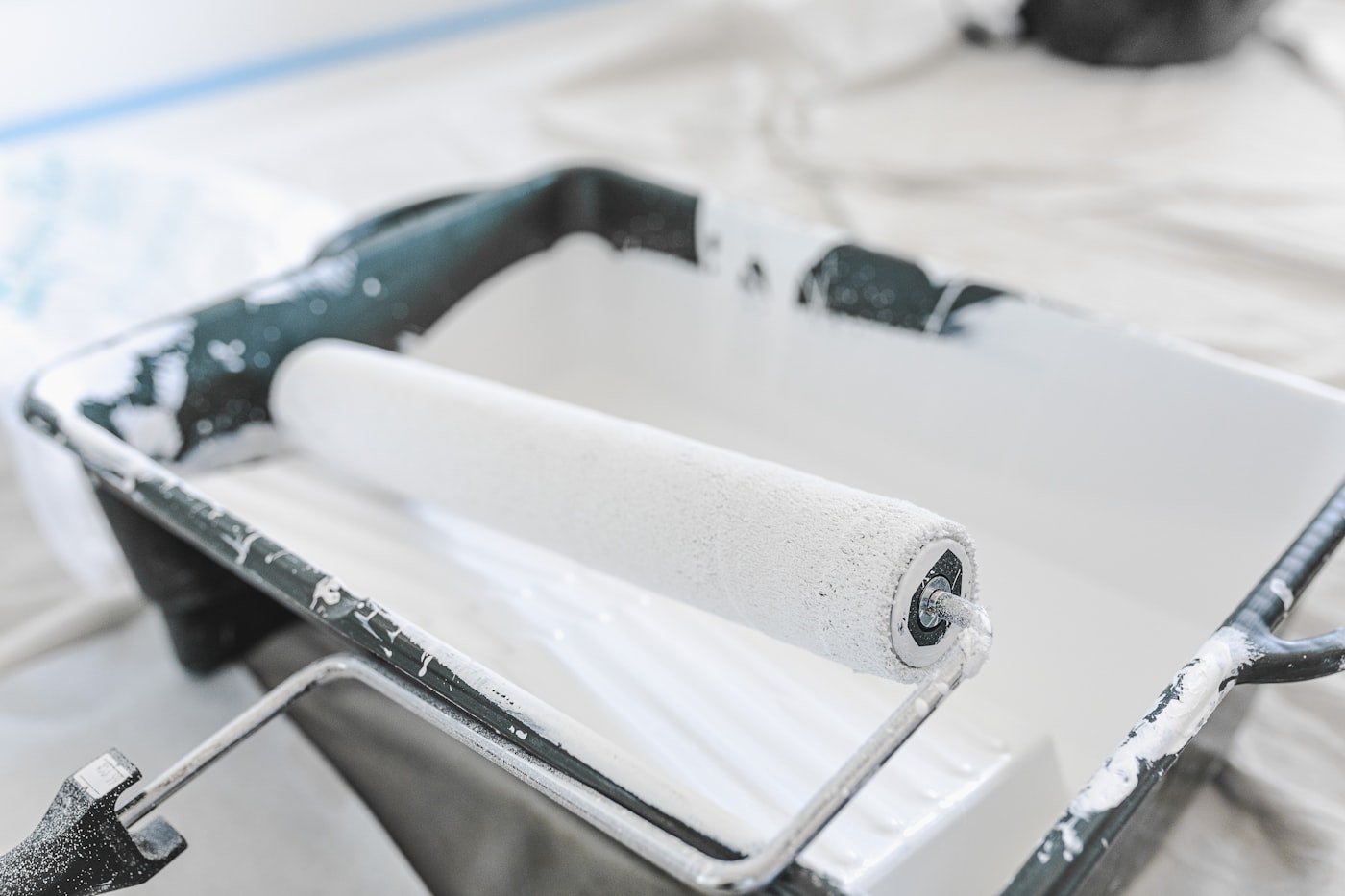 Roller applying paint to a wall in a W pattern
