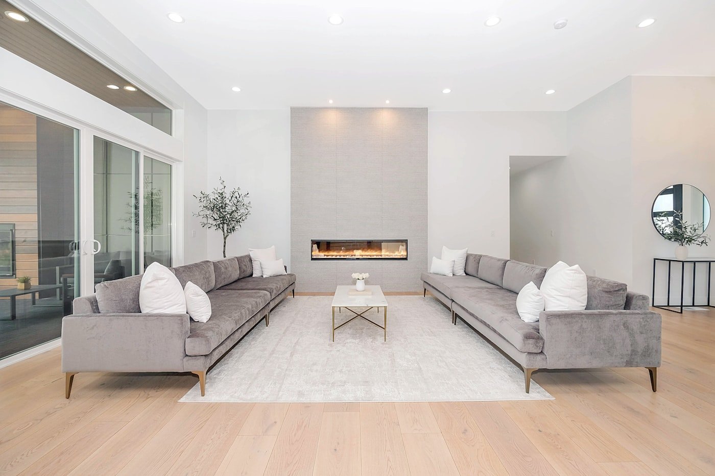 Living room at dusk with a floor lamp, table lamp and wall sconce all lit