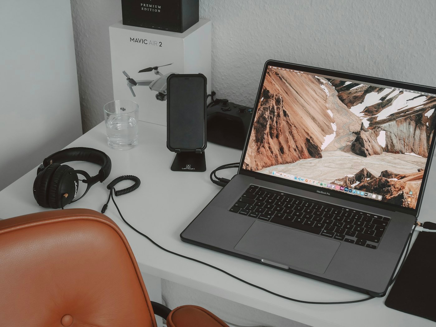 Narrow desk positioned at the foot of a bed facing the wall