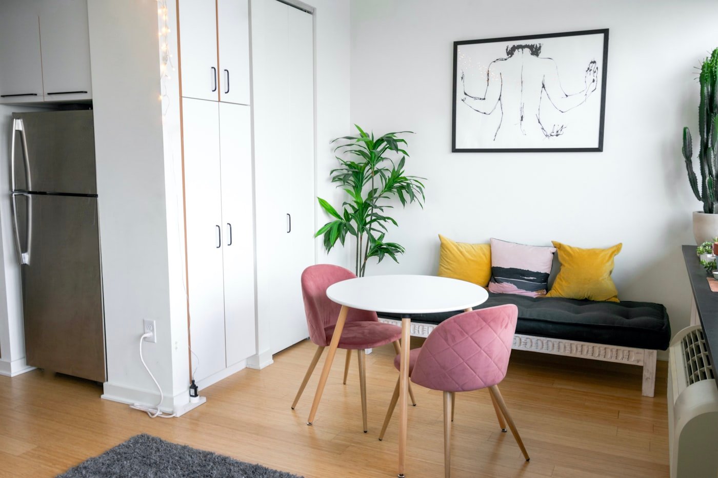 Tall open shelving unit dividing a bed from a living area in a studio