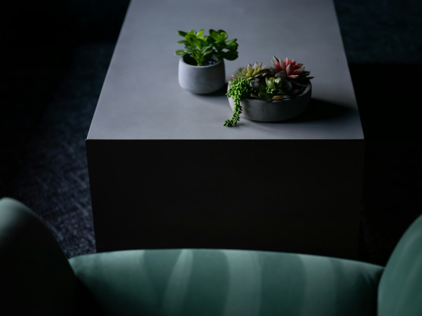 Compact desk placed at the end of a sofa facing the wall in a studio